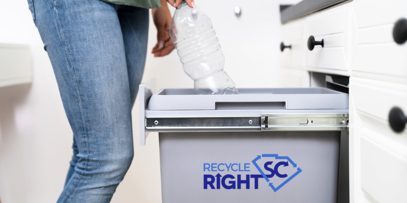 Person puts plastic bottle in recycling bin