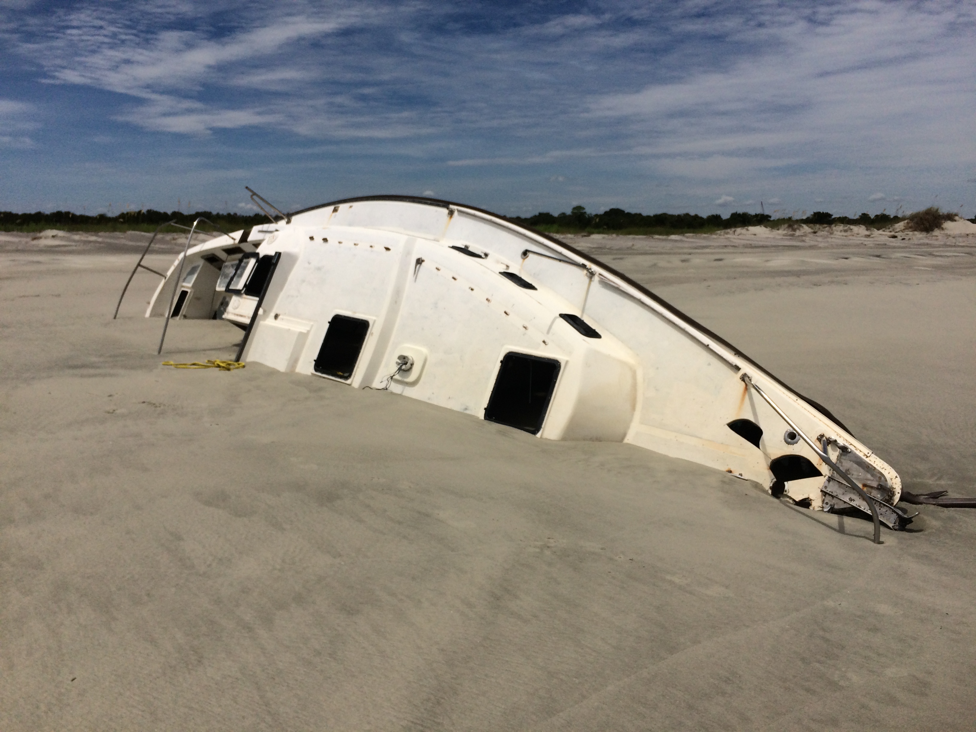 boat partially buried in sand on beach